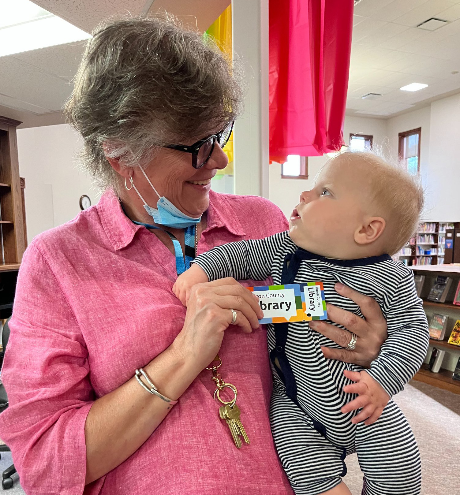 HCL - baby's first card Photo of a library staff member giving a baby their first library card.
