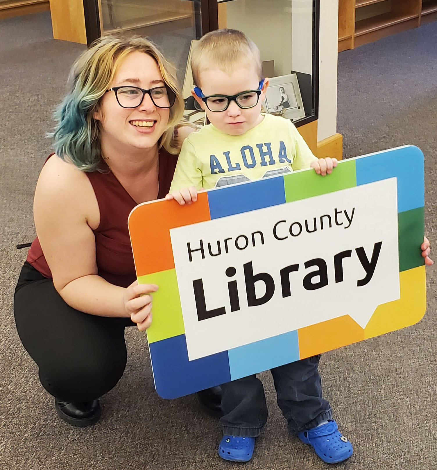 HCL - large library card Image of a woman and a young boy holding a giant Huron County Library card