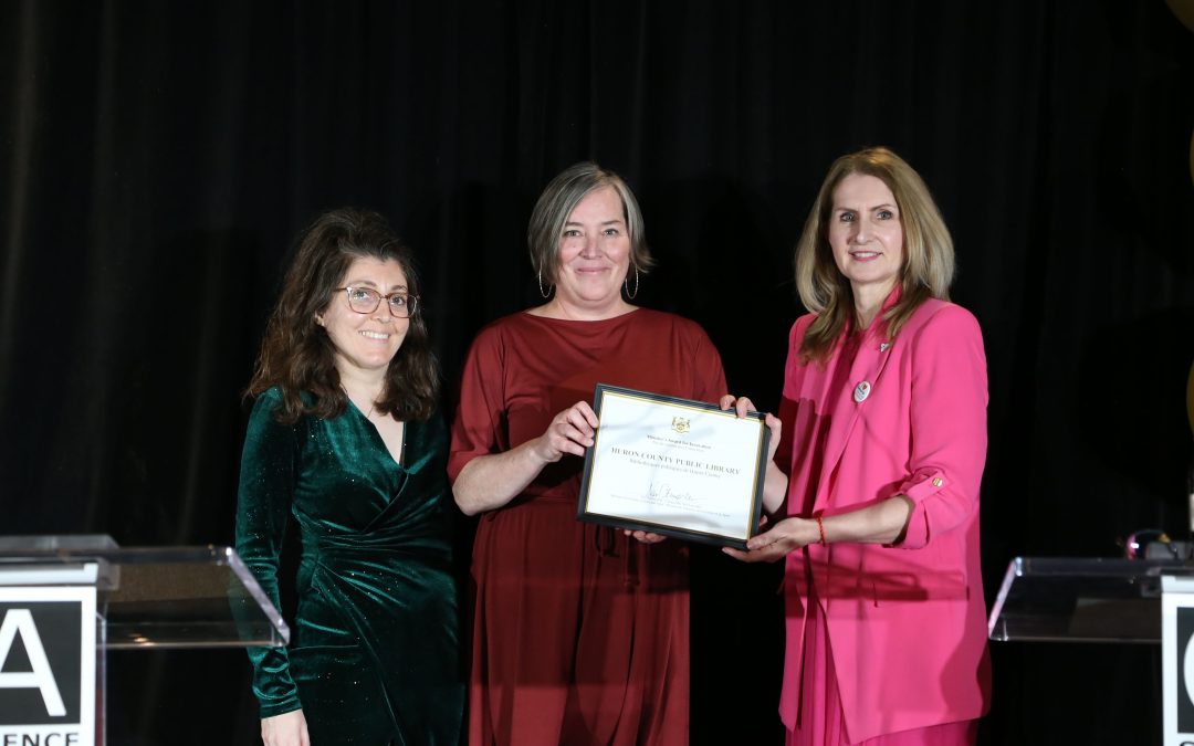 Photo of three women - two on the left are acceptin the Minister's Award for Innovation on behalf of the Huron County Library